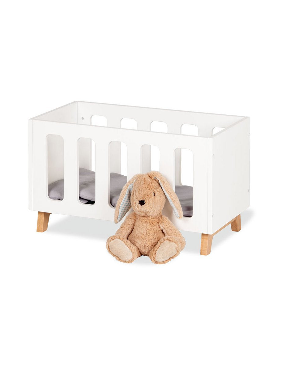 Wit poppenbed Marit met een schattig knuffeltje ervoor. Op wit achtergrond.