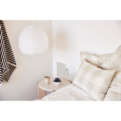 Witte keramieken kom en beige mok op nachtkastje – natuurlijke slaapkamerstyling met minimalistische accessoires.