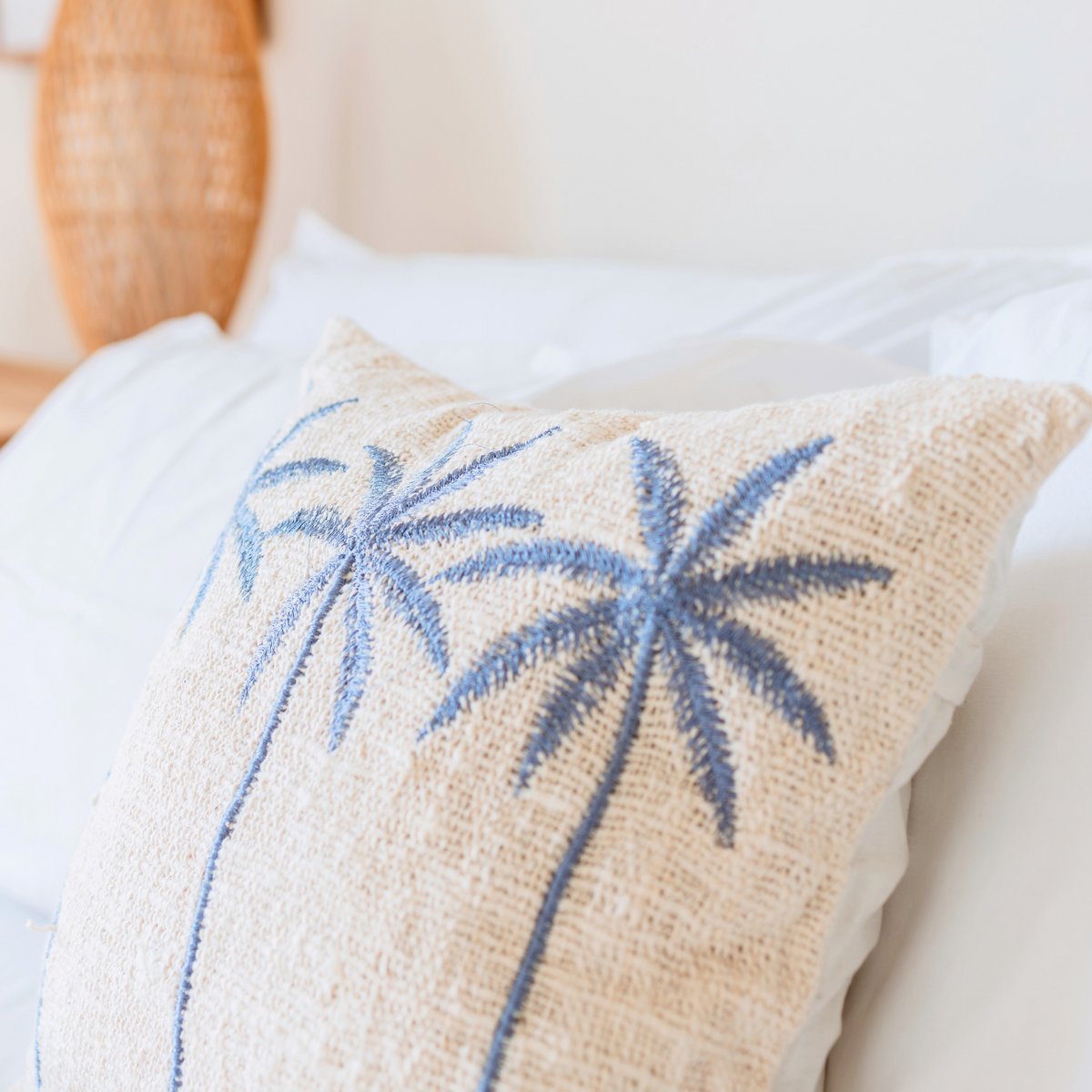 Closeup detail van witte kussenhoes met blauw palmmotief Anarka