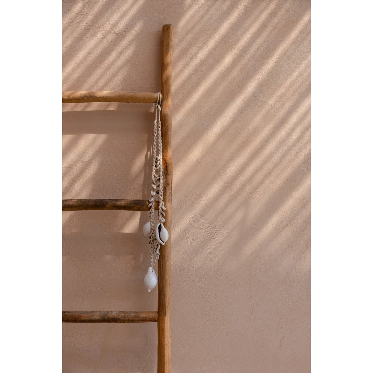 Detail van handgeselecteerde cowrie schelpen in decoratieve ketting