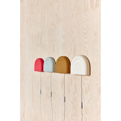 Witte siliconen wandlamp naast 3 andere siliconen wandlampen in verschillende kleuren
