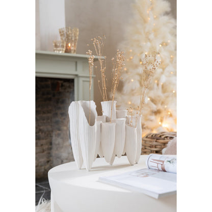 Witte vaas gestyled op tafel met bloemen en woonaccessoires
