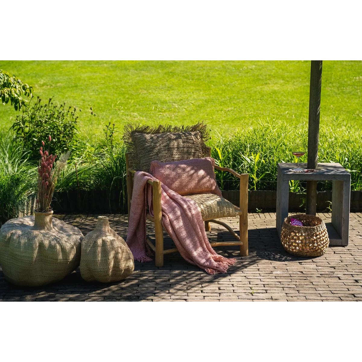 Buitenstyling met zalmroze kussen op loungestoel