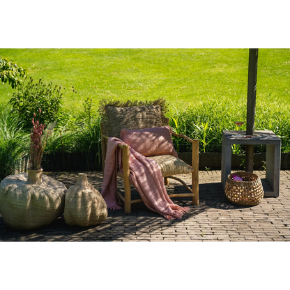 Buitenstyling met zalmroze kussen op loungestoel