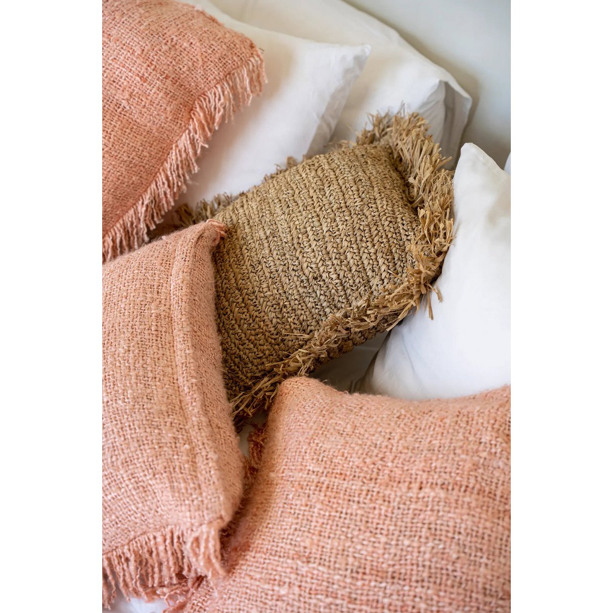 Zalmroze- en groentinten kussens in een interieursetting