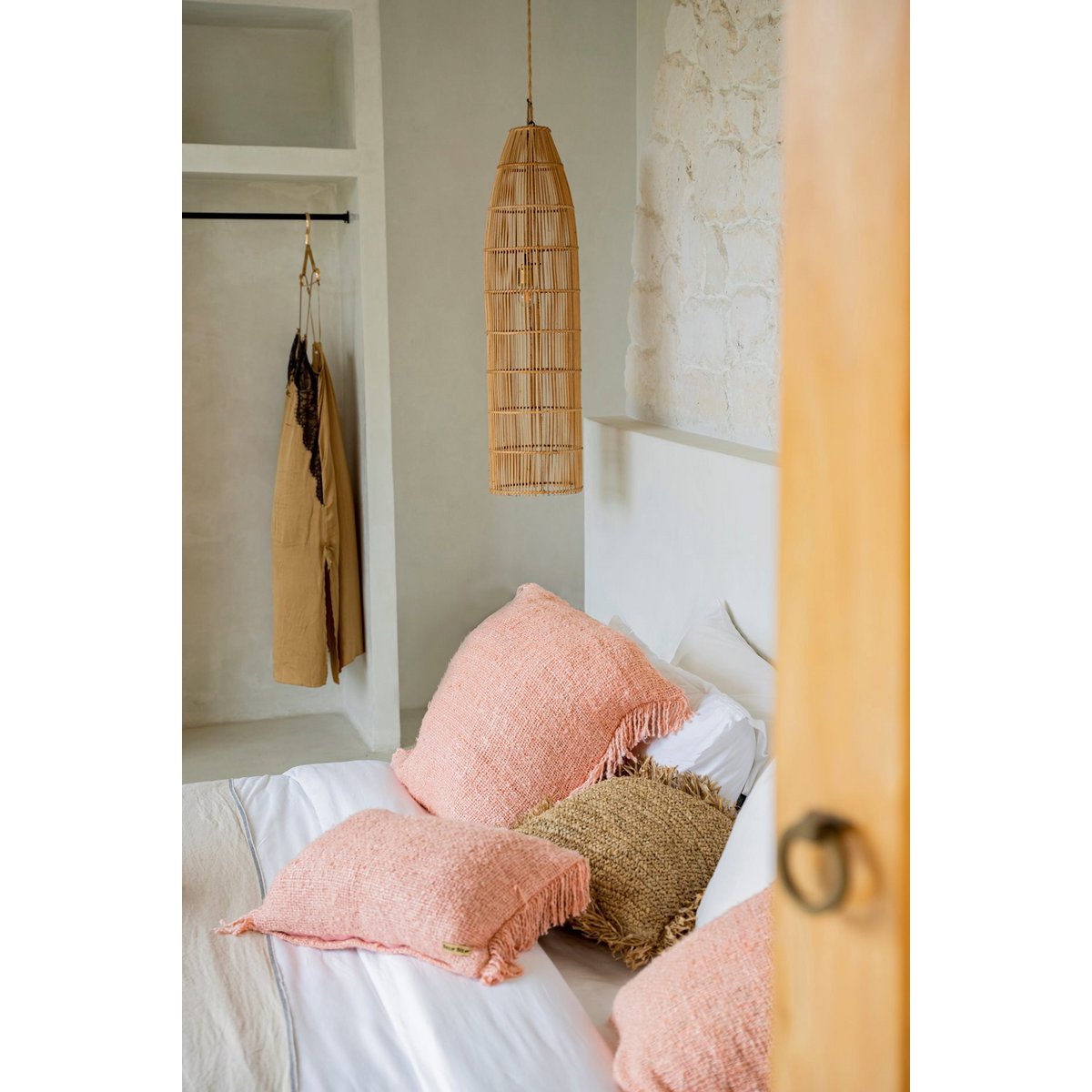 Twee zalmroze kussens in een natuurlijke, lichte woonruimte