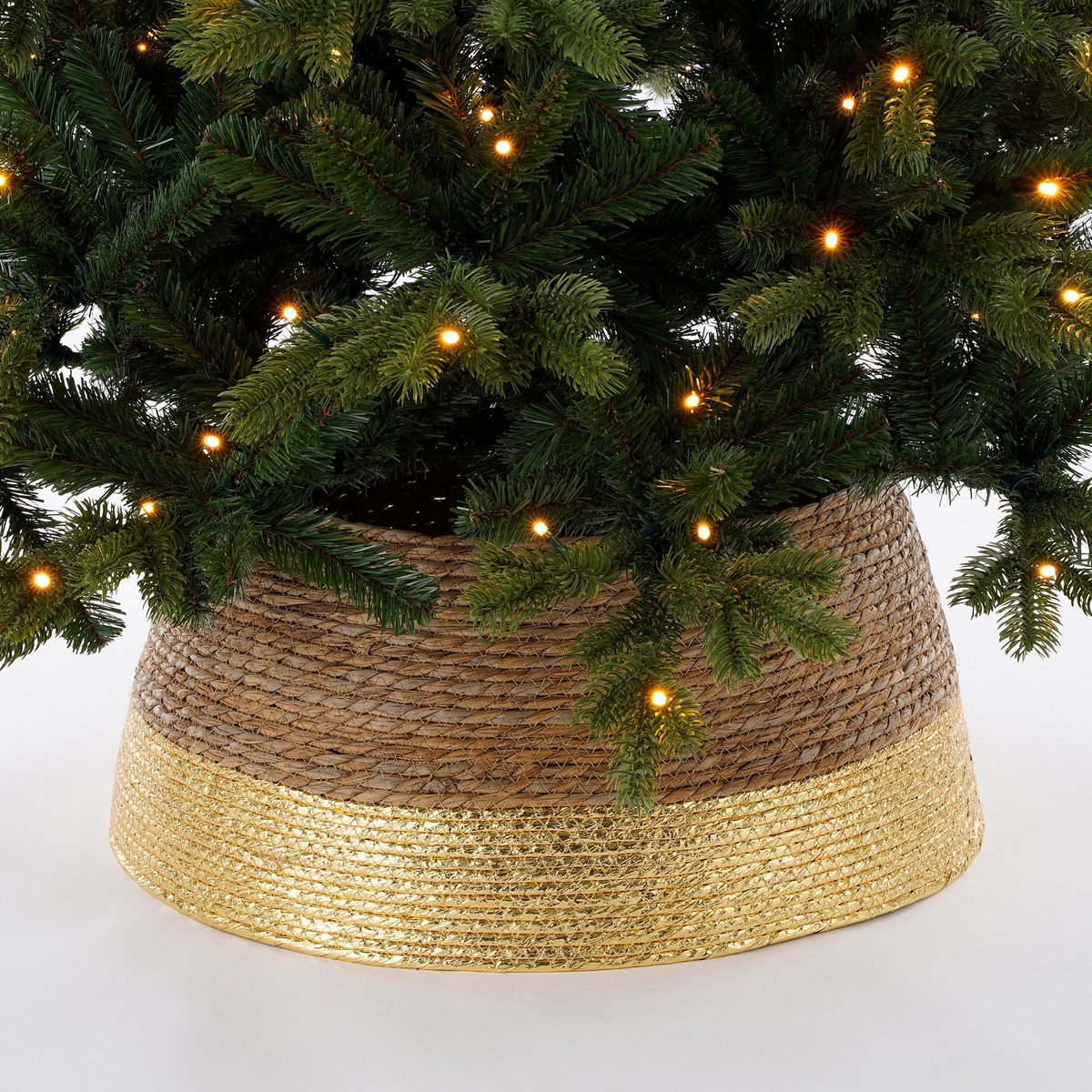 Kerstboommand van rotan met gouden rand – decoratieve afwerking rondom de voet van de boom.
