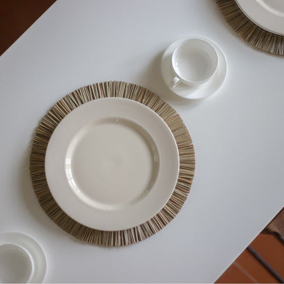 Zeegras placemat rond naturel 35 cm set van 2, 4 of 6 Alang op een aanrecht met twee witte borden erop en een wit kopje ernaast