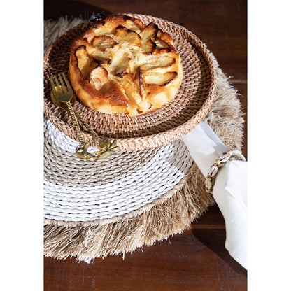 Zeegras raffia placemat naturel wit 45 cm met daarop een gevlochten schaal met een taart erop en een servet ernaast