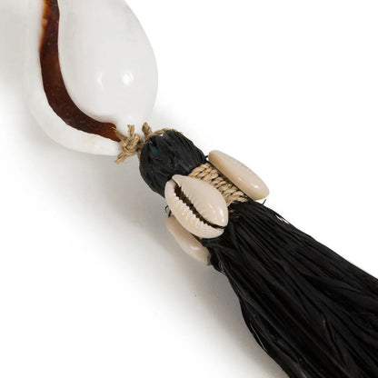 Close-up van schelpdetail met zwarte kwast van de Kubu sleutelhanger