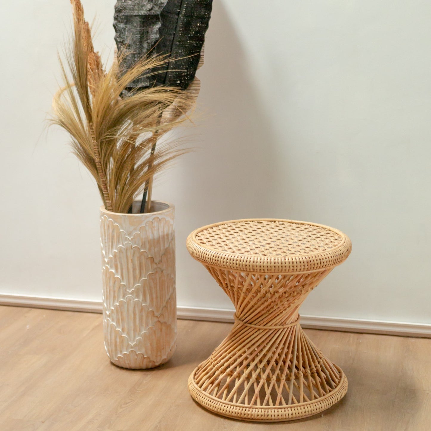 Bijzettafel Luhu naast een lange beige vaas met bloemen en planten erin voor een boho interieur