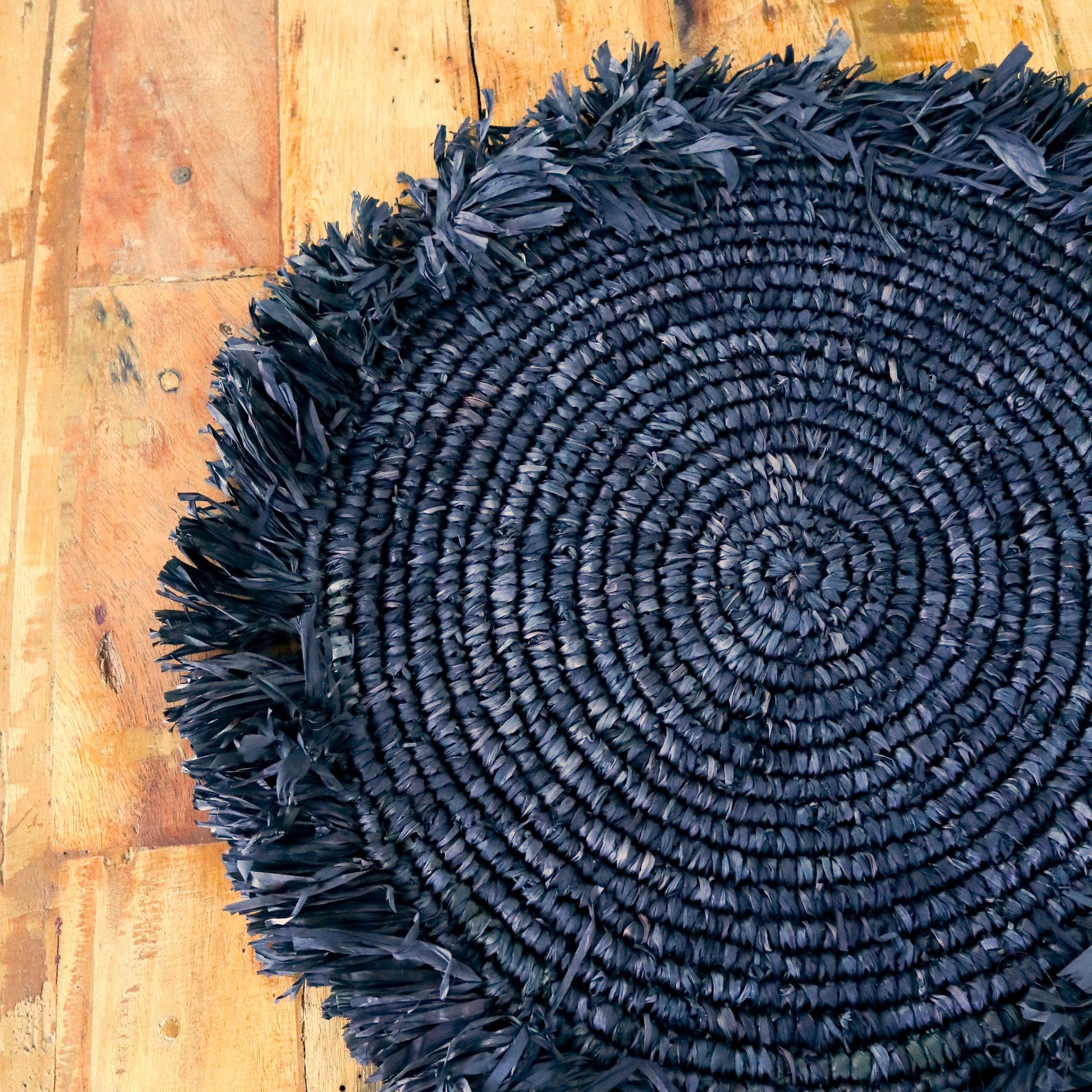 Raffia placemats zwart rond 35 cm Ambon details van het geweven materiaal op houten tafel
