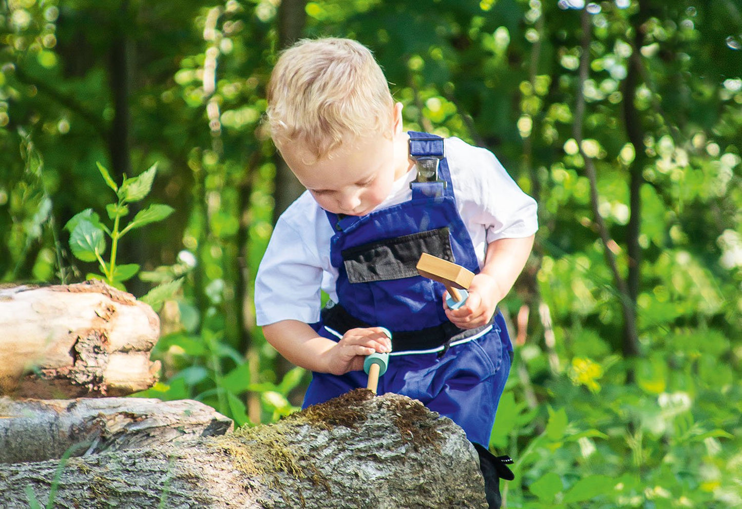 Sfeerfoto Gereedschapstafel Jupp, kindje gebruikt een hamer