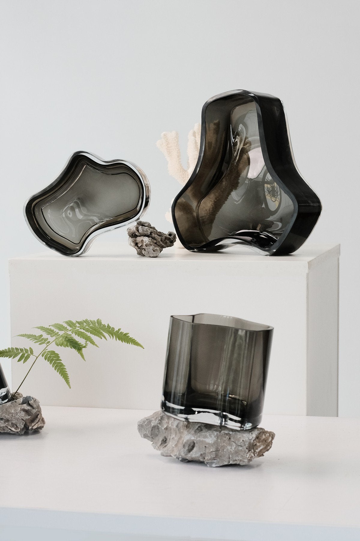 Sfeerfoto geometrische zwarte glazen schaal met andere schalen en vazen