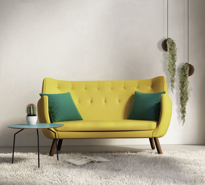 Twee hangende donkere plantenbakken in een modern interieur met een gele bank en groenblauwe kussens 