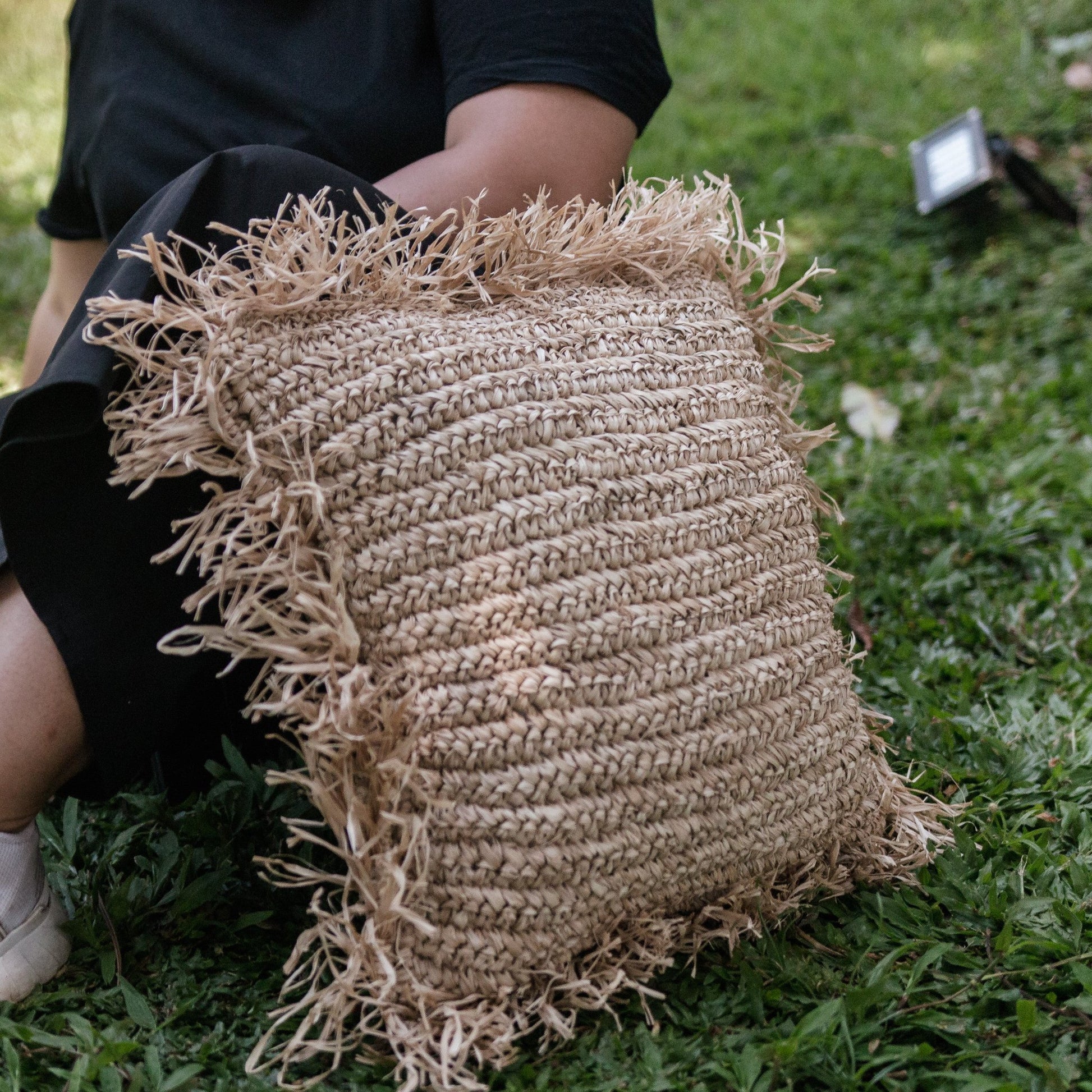 Sierkussen raffia met franjes Gandi buiten op het gras